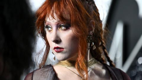 Chappell Roan looks away from camera while wearing a necklace with a cross pendant and a black silk top, pictured at the MTV Video Music Awards in New York in September.