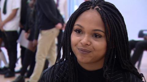 Nkechi Simms is seen in a close-up. Children can be seen in the background