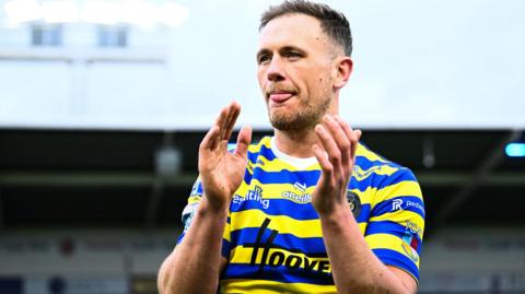 Warrington Wolves' Ben Currie applauds the fans after a match against Leigh Leopards