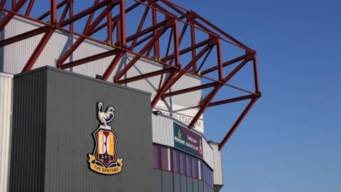 The top corner of Valley Parade stadium with a blue sky in the background