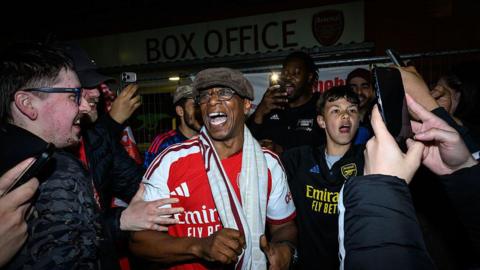 Ian Wright celebrates with Arsenal fans after the Gunners secure Premier League title