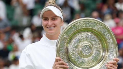 Marketa Vondrousova holding the Wimbledon trophy after winning the women's title in 2023