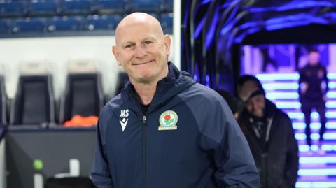 Mike Sheron smiles as he walks out the players' tunnel