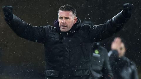 Rob Edwards with his arms out in celebration