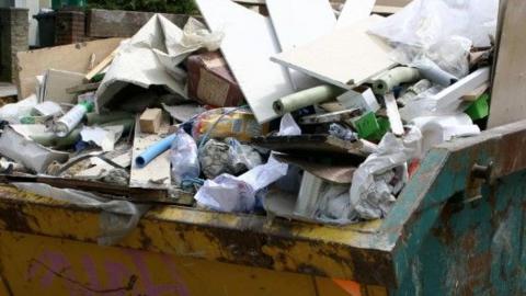 A skip full of discarded builder's waste.