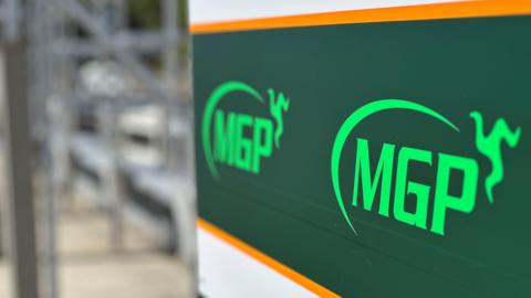 A sign in the pitlane at the grandstand featuring the MGP logo, which includes a semi-circle with a three legs of Mann emblem at one end.