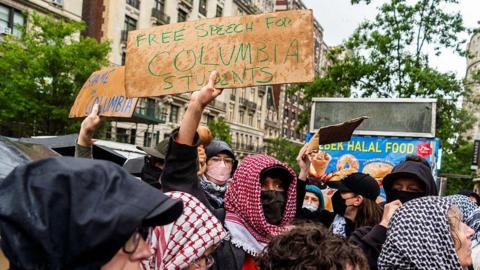 Protesters wearing Arabic scarfs at Columbia. One holds a sign calling for free speech for Columbia students