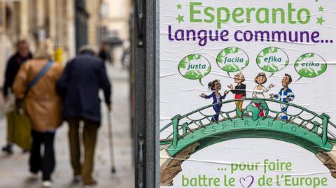 A poster promoting the Esperanto language. Cartoon people stand on a bridge and say Esperanto words. 