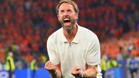 England manager Gareth Southgate with clenched fists screams with passion in the direction of England fans in a scene of celebration