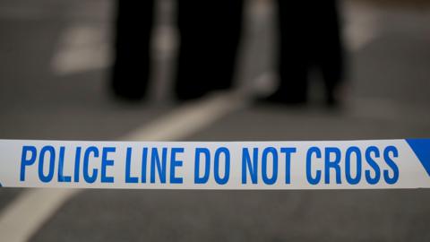 White and blue police tape, reading: "Police line do not cross".