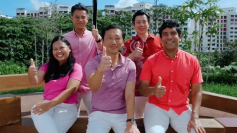 A screenshot of a TikTok video by Ong Ye Kung, showing him and four other PAP members wearing white pants and red or pink shirts. They are sitting on a park bench and giving the thumbs-up sign.
