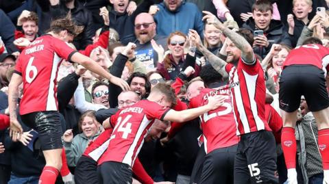 Lincoln celebrate their late winner against AFC Wimbledon
