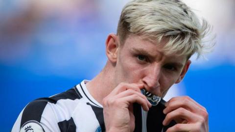 Anthony Gordon kisses the Newcastle badge on his shirt