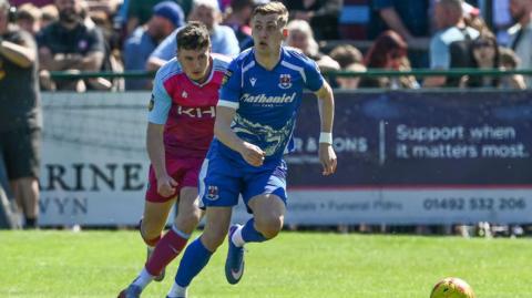 Penybont's Nathan Wood is pursued by Colwyn Bay's Matty Hill