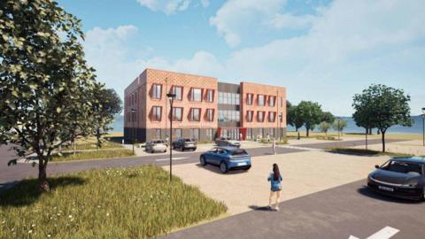 A CGI image of the proposed GP surgery in Wallingford. The image shows a peach coloured three-storey rectangular building with large square glass windows. There are cars parked in bays in front of the building and larger sections for cars to park over the road. There are trees dotted around the image, the sky is a bright blue with clouds and there is a CGI image of a woman with long brown hair walking towards the building.