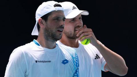 Julian Cash and Lloyd Glasspool discuss tactics during their Australian Open second-round match