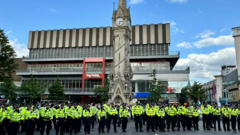 A wall of police officers separating demonstrators and stood in front of the clock tower in Leicester