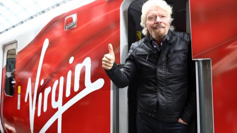 Richard Branson boarding a Virgin train