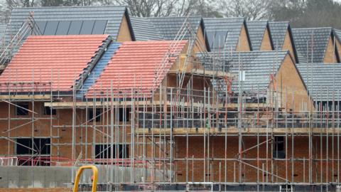 Homes under construction with scaffolding around them