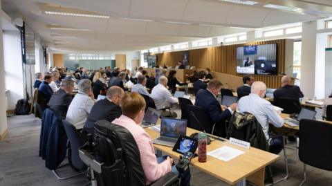 A group of people sat in a conference room.