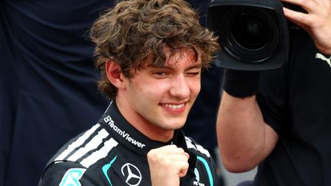 Kimi Antonelli clenches his fist, winks and smiles in celebration after winning the Monaco Grand Prix