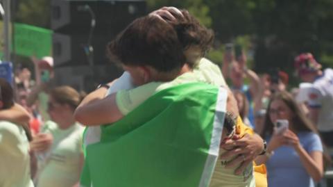 Jordan and Cian Adams embrace wrapped in an Irish tricolour flag after completing their Irish marathon challenge in Dublin city centre.
