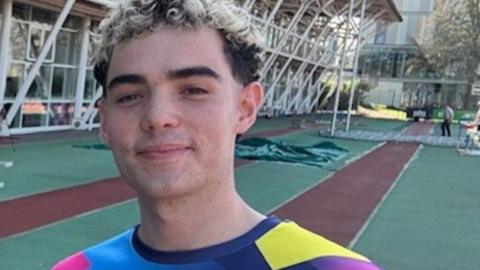 Charlie at a running track wearing a sports top