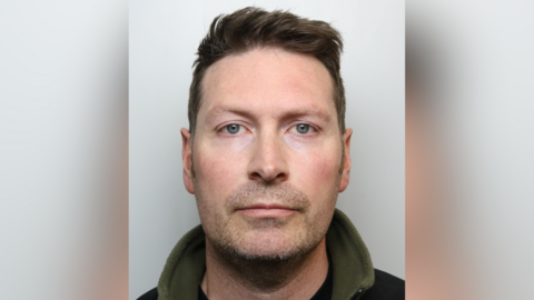 Nicholas Fielding-Smith's mugshot. He has short, dark hair and is looking at the camera.