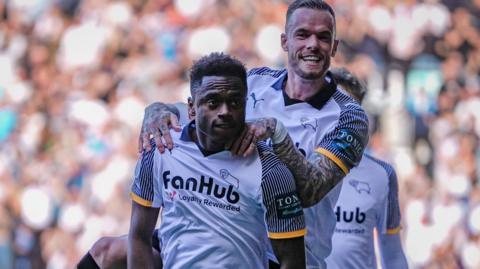 Jaydon Banel is jumped on by a team-mates as he celebrates scoring for Derby