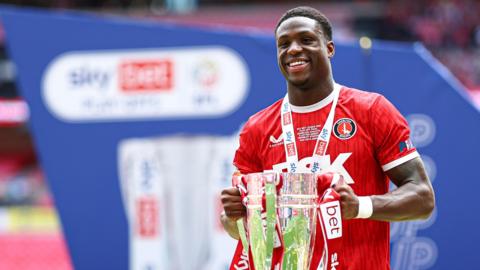 Thierry Small holds the League One play-off trophy
