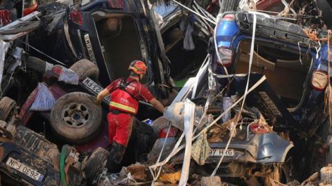 Members of the fire brigade, which are part of a search and rescue unit, carry out work as cars and debris block a tunnel after the recent flash flooding in the nearby municipality Benetusser 