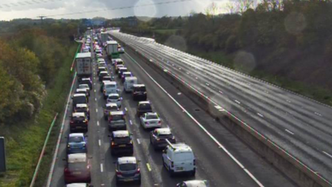 Traffic queues as far as the eye can see on the left-hand carriageway, while the right one is empty
