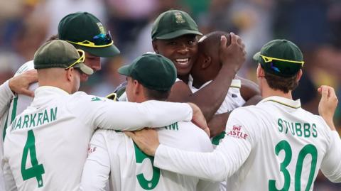 South Africa bowlers Kasigo Rabada and Lungi Ngidi are mobbed by their team-mates after a wicket 