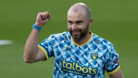 Jake Lintott punches the air with his right fist after taking a wicket for Birmingham Bears