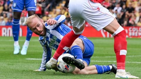 Sheffield Wednesday's Barry Bannan tackles a Wrexham player along the floor