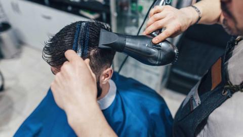 Barber trimming hair with clippers