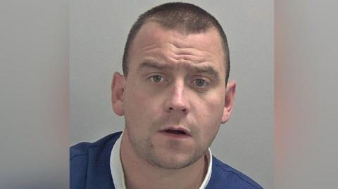 A mugshot of Jakob Walpole wearing a blue Rangers t-shirt