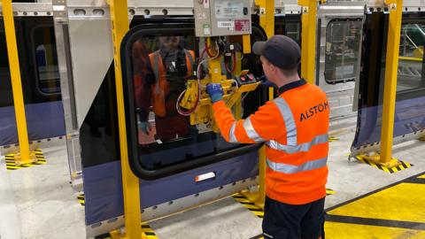 Engineers work on the shell of a new Elizabeth Line train at a factory in Alstom