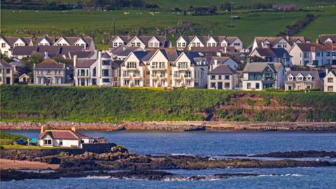 A view of Portballintrae, showing the coastline and houses on the bank