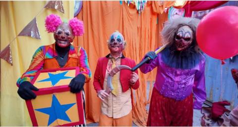 Three people dressed as scary clowns