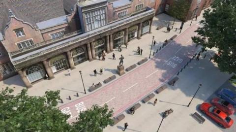 An aerial artist's impression of the road - there is lettering on the floor which indicates sections of the road form a bus gate, and there are people milling about the front of an elaborate railway station building.