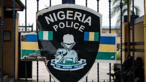 The emblem of the Nigerian Police at a gate of a police station