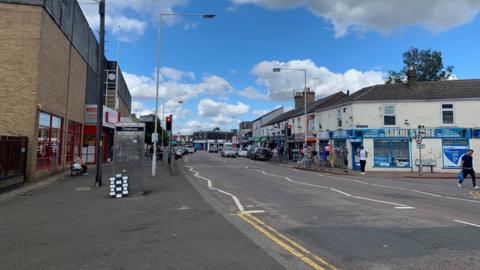 Lincoln Road - with shops on either side and traffic lights in the road 