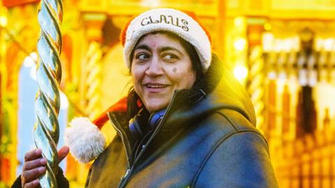 A picture of Gurinder Chadha in a Santa hat