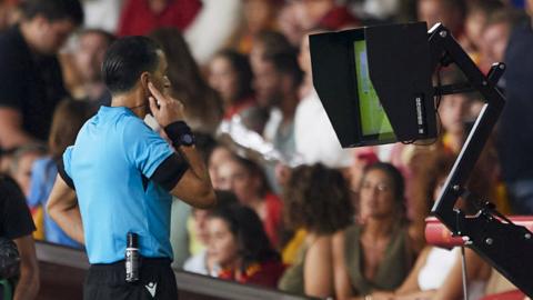 Referee Serdar Gozubuyuk checks VAR for a potential foul as Scott McTominay scored during a UEFA Euro 2024 Qualifier at the Estadio De La Cartuja