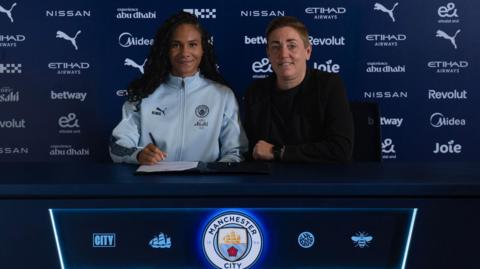 Jade Rose poses for a photo while signing her contract