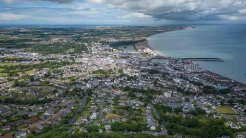 An ariel view of Ramsey with the arching coastline and a lot of buildigs