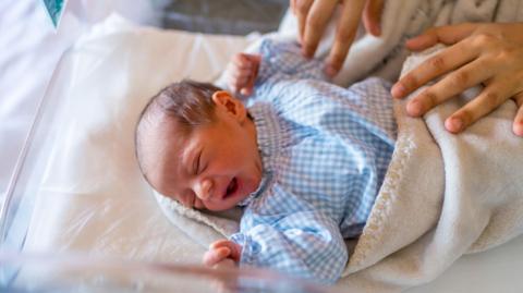 Top view of a healthy newborn baby on the crib of the hospital