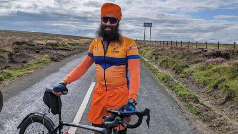 Jagdeep Singh with his bike wearing cycle gear and a turban