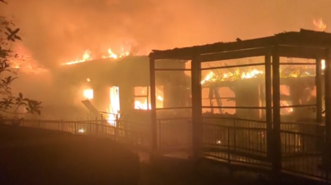 A blurry picture of a building on fire in the dark. 